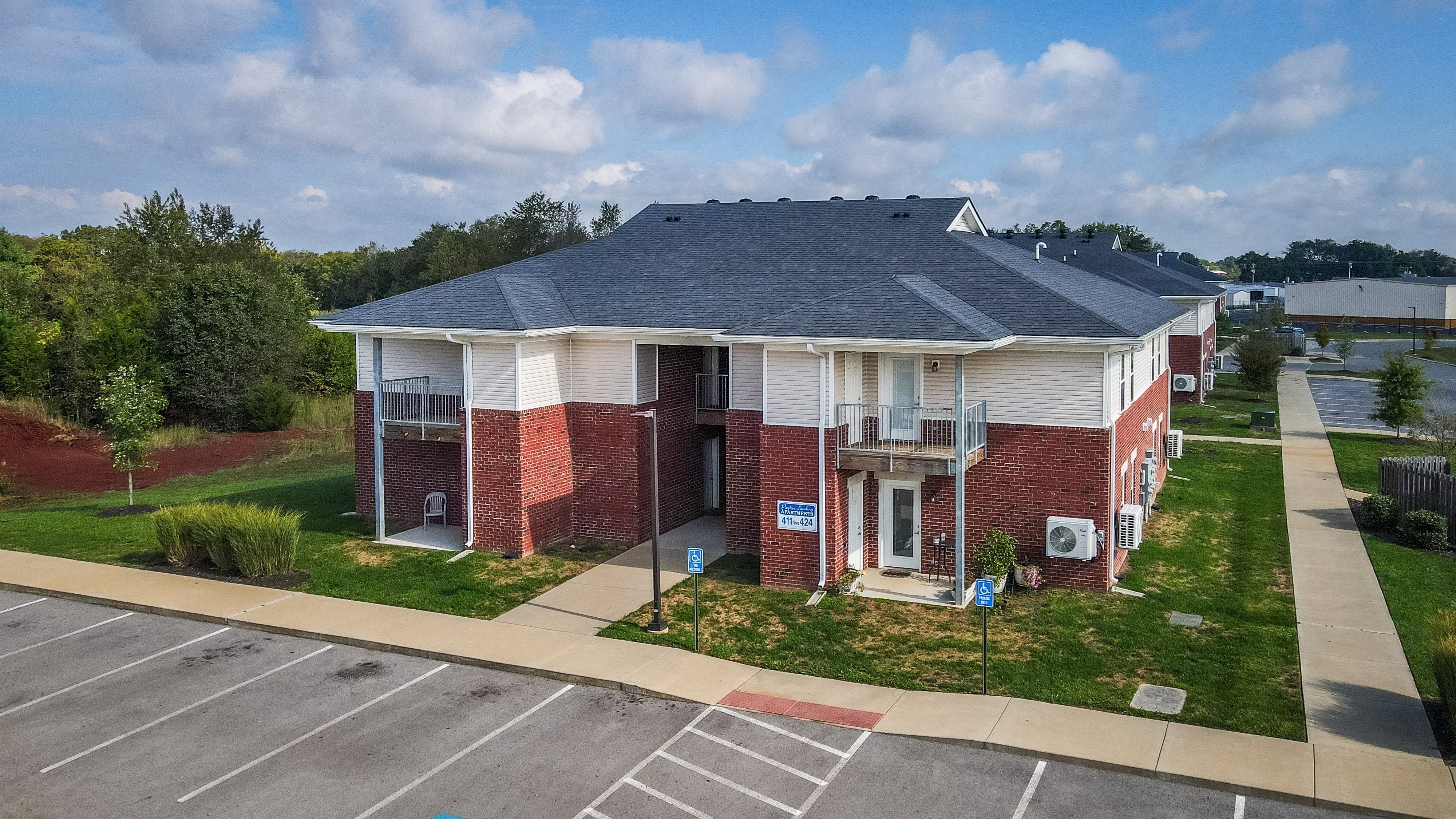 an aerial view of a brick house with a grey roof